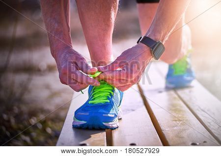 Athlete during training tying shoelaces on sneakers summer.