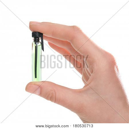 Female hand holding perfume sample on white background