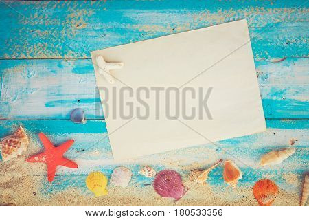Summer background - Blank old paper with starfish shells coral on wood table background. vintage color tone styles.