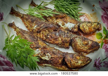 Fried fish with sambal belacan and vegetable side dish.Fried fish with sambal is a popular home-style dish in Malaysia,Singapore,Indonesia & Thailand.