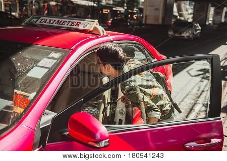 BANGKOK THAILAND - JANUARY 22: Street scene in downtown Bangkok of a man trying to catch a taxi on January 22 2017 in Bangkok.