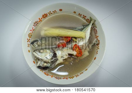 Fish soup with sliced fish,chilli and lemon grass
 on white background.The health benefits of fish soup with lemon grass include relief from stomachdisorders,insomnia,respiratorydisorders,fever,aches,infections,rheumatism & edema.