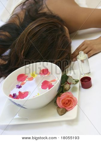 Žena čeká smyslné celého těla masáž ukazující misku provoněné květinové vody a bo