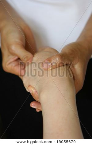 Una donna riceve un massaggio alle mani come parte di un trattamento di massaggio olistico