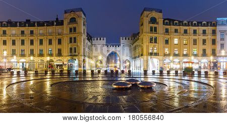 Panoramic view of Karlstor Gate and Karlsplatz Square during morning blue hour, Munich, Germany