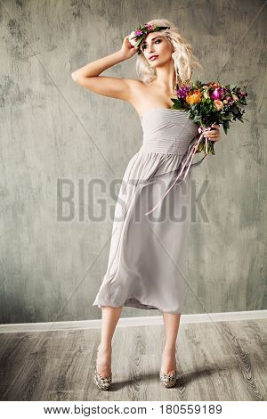 Summer Beauty Portrait of Beautiful Blonde Model Woman with Blonde Hair Blowing Dress and Flowers