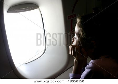 En ung flicka ser ut genom ett fönster i airoplane
