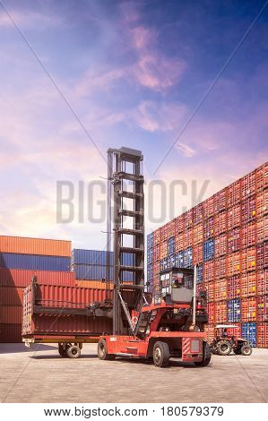 Forklift Truck Lifting Cargo Container In Shipping Yard Or Dock Yard Against Sunrise Sky With Cargo