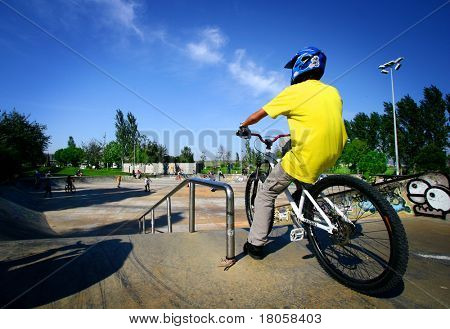 男性の若者約スケート ランプダウン彼の自転車に乗ること。