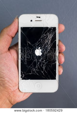 Chiangrai Thailand: March 17 2017 - Human hand holding broken Apple iPhone smartphone and showing Apple logo on screen