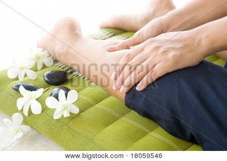 Massaggiatore dando lady paziente un massaggio gambe.