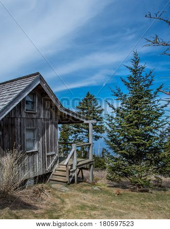 Cirrus Clouds Above Weathered Cabin in mountains
