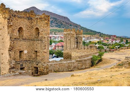 Walls of Genoese fortress in Sudak Crimea. Scenic views of rocky cliffs near ancient Genoese fortress and modern city in the background