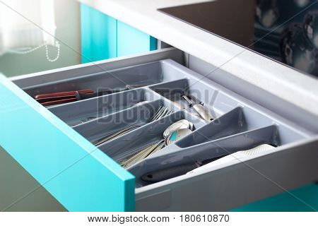 New kitchen drawer with utensils on blue kitchen