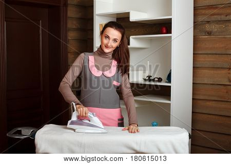 Young woman in uniform with steam iron