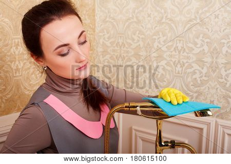 Female hands in rubber gloves cleans bathroom