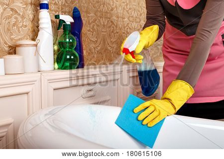 Female hands in gloves cleans bathroom