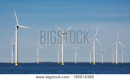 Offshore farm windturbines near Dutch coast against blue sky