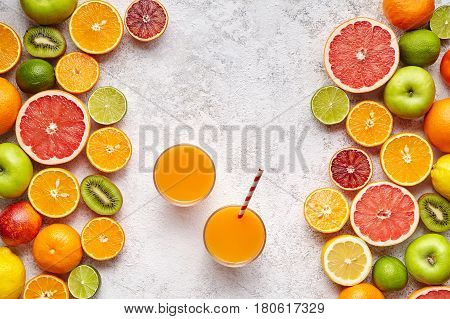 Fresh juices or smoothies with citrus fruit, apple, kiwi on light background. Top view, selective focus. Detox, dieting, clean eating, vegetarian, vegan, fitnes healthy lifestyle concept