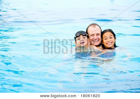Mann mit zwei Kindern Spaß im tropischen Schwimmbad