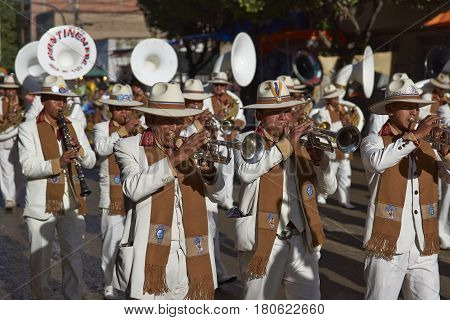 ORURO, BOLIVIA - FEBRUARY 26, 2017: Band of a Morenada dance group in colourful outfits parading through the mining city of Oruro on the Altiplano of Bolivia during the annual Oruro Carnival.
