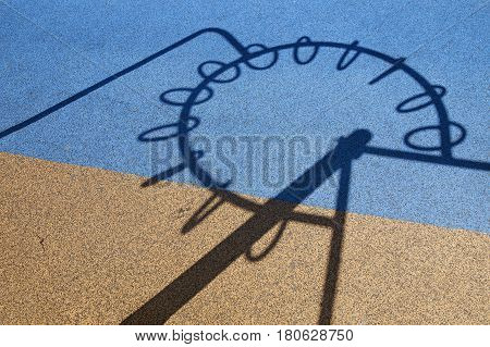 shadow from the playground on the rubber surface. The shadow from the playground resembles the symbol of the European Union on a two-color covering, which resembles the flag of Ukraine