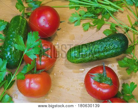 The healthy fresh wet vegetables on the wooden table