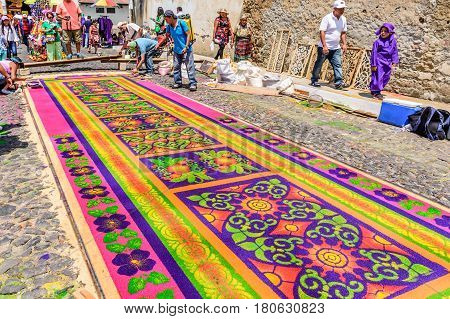Antigua, Guatemala - March 26 2017: Locals make dyed sawdust Lent procession carpet in colonial town with most famous Holy Week celebrations in Latin America.
