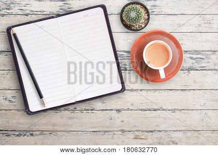 Blank notebooks and black pencil with cup of coffee on wood table background. top view with copy space for design