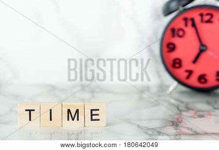 Red alarm clock on marble sureface with time text copy space