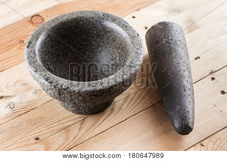 food stone mortar and pestle on wooden background Asian kitchen ware with space for text.