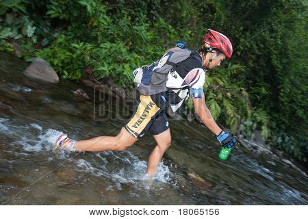 SABAH, MALEISIË - 2 APRIL.  Een racer uit een deelnemende team maakt zijn weg in een rivier in de 