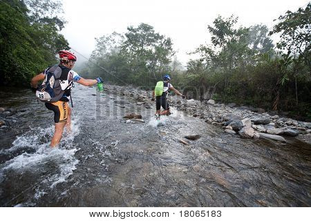 SABAH, MALEISIË - 2 APRIL.  Een racer uit een deelnemende team maakt zijn weg in een rivier in de 