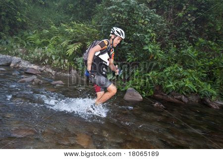 SABAH, MALEISIË - 2 APRIL.  Een racer uit een deelnemende team maakt zijn weg in een rivier in de 