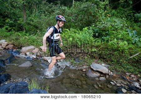 SABAH, MALEISIË - 2 APRIL. Een racer uit een deelnemende team maakt hun weg langs en over een ri