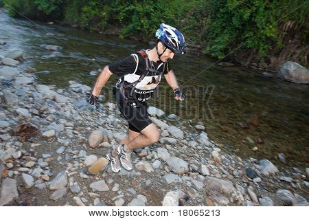 SABAH, MALEISIË - 2 APRIL. Een racer uit een deelnemende team maakt hun weg langs en over een ri