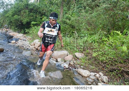 SABAH, MALEISIË - 2 APRIL. Een racer uit een deelnemende team maakt hun weg langs en over een ri