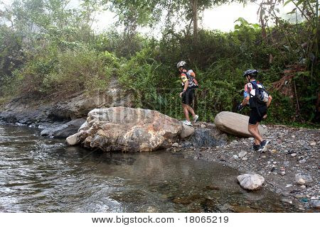 SABAH, MALEISIË - 2 APRIL. Een racer uit een deelnemende team maakt hun weg langs en over een ri