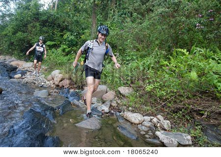 SABAH, MALEISIË - 2 APRIL. Een racer uit een deelnemende team maakt hun weg langs en over een ri