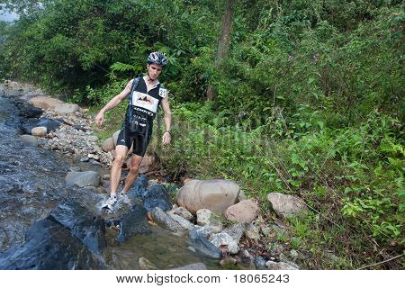 SABAH, MALEISIË - 2 APRIL. Een racer uit een deelnemende team maakt hun weg langs en over een ri