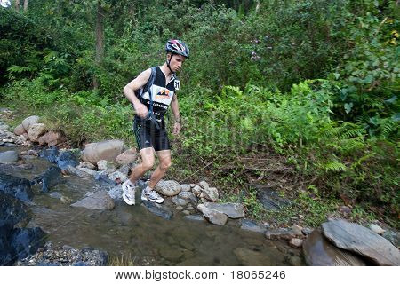 SABAH, MALEISIË - 2 APRIL. Een racer uit een deelnemende team maakt hun weg langs en over een ri