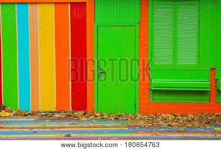 Colorful house. Bright colorful wall facade with green door and wooden window