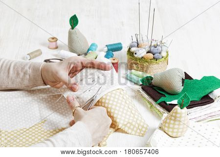 Needlewoman Cuts Out A Pattern For The Handmade Toy With Scissors.