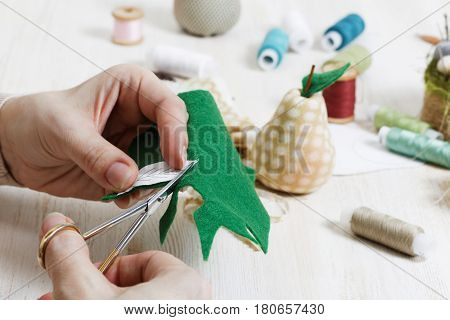 Closeup Hands Of The Needlewoman Hold Scissors And Cut Out A Pie