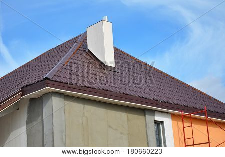 Construction or repair of the rural house with eaves windows chimney roofing fixing facade insulation plastering and painting walls. Painting House Facade Wall. Metal Tiled Roofing. Roof Repair.
