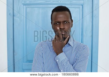 In search of decision. Young talanted architecture engineer or business man is looking for the answer for the important questions. With thoughtful face expression he looks forward holding his chin with one hand.