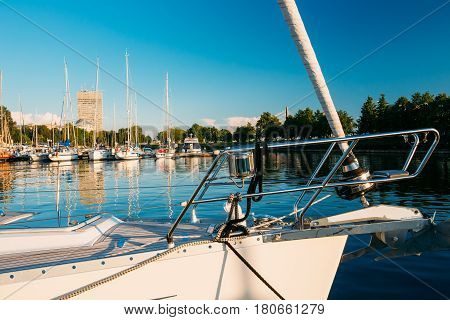 Riga, Latvia. Bow of  White Yacht Moored At City Pier Harbour Bay And Quay In Summer Sunny Evening. Western Dvina River.