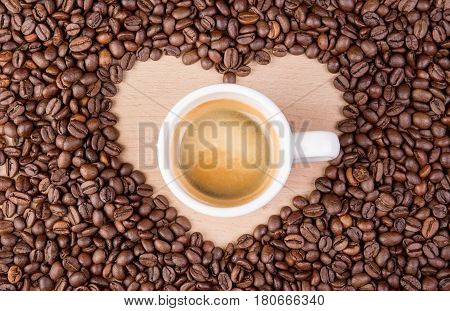 Heart coffee frame made of coffee beans on wooden texture