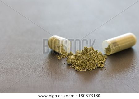 Green Herb Powder Capsules On Blackboard Background