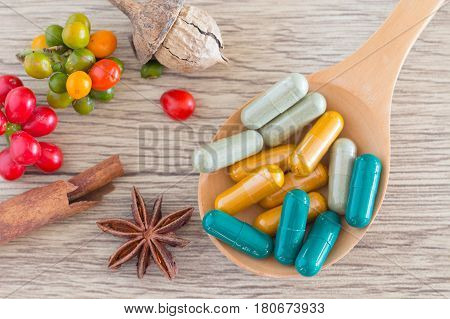 Green Herb Powder Capsules On Wooden Spoon